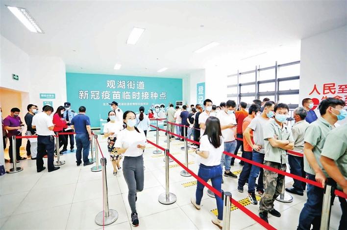 观湖街道新冠疫苗接种点,预约市民有序排队登记接种.