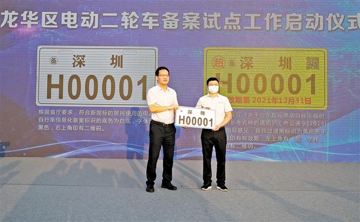 区委书记、区长王卫为市民发放号码为深圳H00001（白牌）的标识牌。.jpg